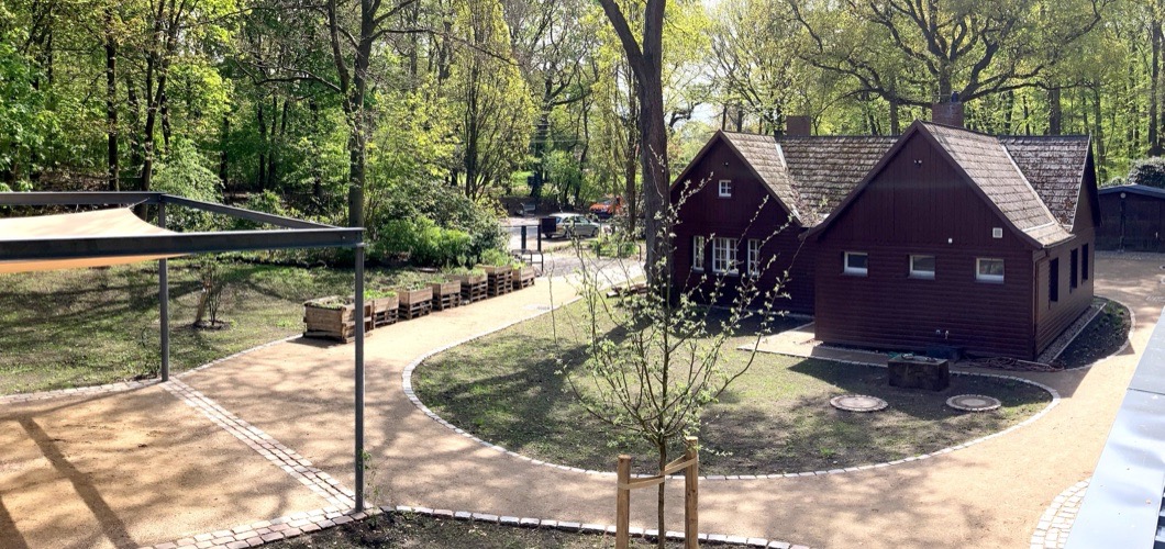 Blick über das Gelände des Heilgartens Hamburg mit Waldhaus, Park-Deck und naturnahem Garten